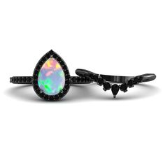 a black diamond ring with an opal in the center on a white background,