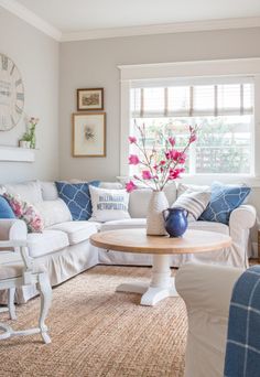 a living room filled with furniture and a large clock mounted to the wall above it