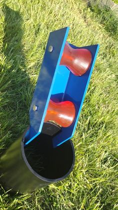 a blue and red object sitting in the grass