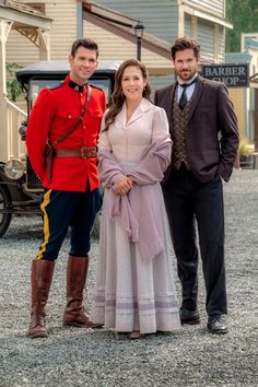 two men and a woman standing next to each other