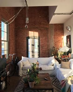 a living room with brick walls and white furniture