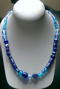 This one-of-a-kind beaded necklace is made with assort blue glass beads. Toggle clasp. Measures 23" long end to end. Blue Glass Beaded Necklaces As A Gift, Handmade Blue Oval Beads Jewelry, Handmade Blue Oval Bead Jewelry, Handmade Blue Glass Necklaces, Blue Oval Bead Jewelry With Large Beads, Blue Oval Beads Necklaces For Jewelry Making, Blue Glass Necklace With Polished Beads, Handmade Blue Jewelry With Oval Beads, Blue Single Strand Necklace With Oval Beads