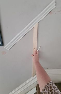 a person holding a pencil up to the ceiling