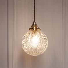 a glass light fixture hanging from a ceiling