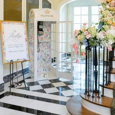 a phone booth is decorated with flowers and an ornate checkerboard floor in the foyer