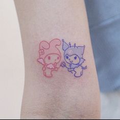 two small tattoos on the arm of someone's left arm, one with an animal and another with a cat