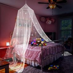 a bed with a white net over it and stuffed animals sitting on the top of it