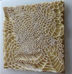 a piece of art made out of paper on top of a white surface with an intricate design