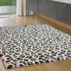 a leopard print rug on the floor in front of a bathroom sink and window with sliding glass doors