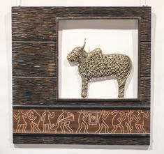 an animal is in a wooden frame on the wall