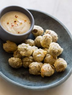 a blue plate topped with meatballs and dipping sauce