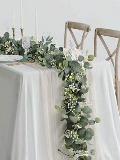 the table is decorated with greenery and candles