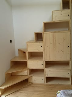 an empty room with wooden shelves and stairs