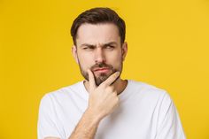 a man is holding his hand to his chin and looking at the camera with an intense look on his face