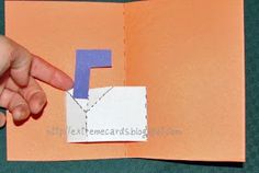 a hand is pointing at a piece of paper with the letter f on it