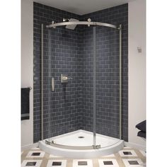 a corner shower with a glass door in the middle and tile on the wall behind it