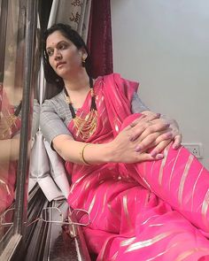 a woman in a pink sari sitting on a train