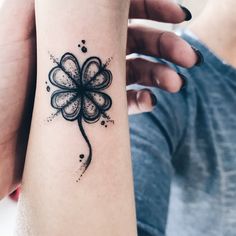 a woman's arm with a clover tattoo on it