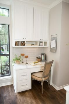 a home office with white cabinetry and wooden flooring is pictured in this image