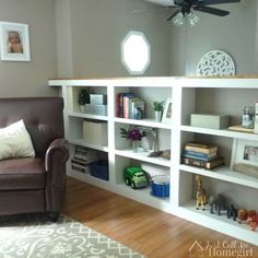 a living room with a couch, book shelf and ceiling fan in the middle of it