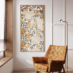 a chair in front of a window with a painting hanging on the wall behind it