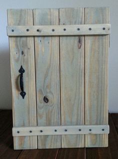 a close up of a wooden box on a wood floor with screws and nails