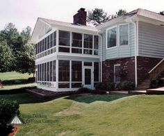 a large house sitting on top of a lush green field