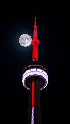 the moon is shining brightly in the night sky above a tall tower with a clock on it's side