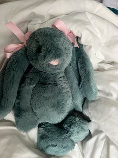 a blue stuffed animal sitting on top of a bed