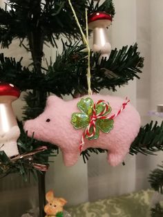 a pink pig ornament hanging from a christmas tree