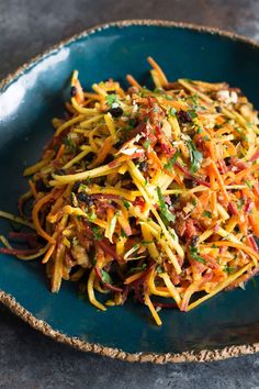 a blue plate topped with shredded cheese and vegetables