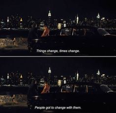 two people are sitting in the back of a car at night with city lights behind them