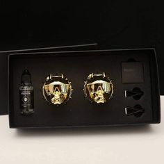 two gold - plated helmets are in a black box next to an electronic device