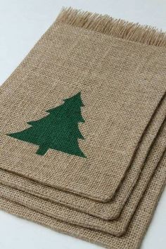 three burlap placemats with a green christmas tree on one side and two brown ones on the other