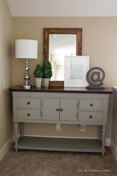 a white dresser with two lamps and a mirror on top of it in a room