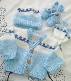 a knitted baby sweater and booties on a bed