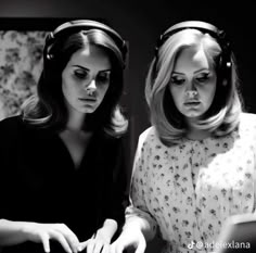 two women in headphones are looking at something