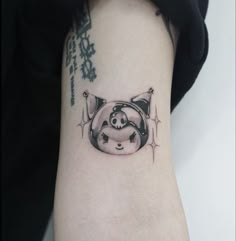 a small pig tattoo on the arm with chinese characters around it and an inscription below