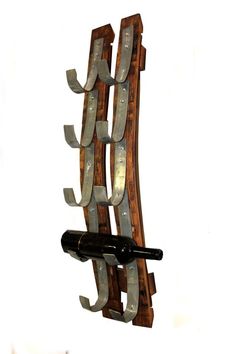 a wine bottle is hanging from a wooden rack with metal strips attached to the wall