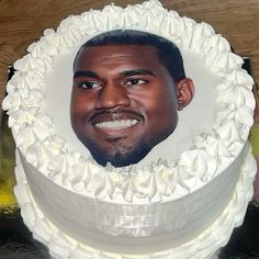 a man's face is shown in the middle of a white frosted cake