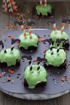 six cupcakes with green frosting and sprinkles on a tray