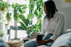 a woman sitting on a couch holding a coffee mug