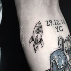 a small tattoo on the arm of a man with a rocket ship and an elephant