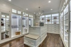 a walk in closet with white cabinets and drawers