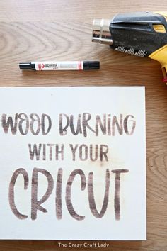 wood burning with your cricut sign on a table next to some construction tools