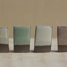 three small vases sitting on top of a wooden table