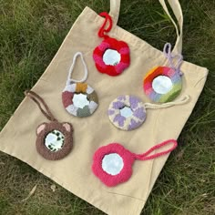 four handmade purses sitting on top of a cloth bag in the middle of grass