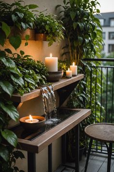 candles are lit on a balcony railing with greenery and potted plants in the background