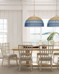 a dining room table and chairs in front of a large window with the ocean view