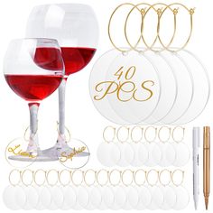 the wine glass is next to some paper circles and gold writing on it, along with several other items